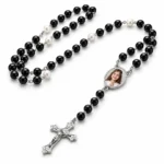 Rozariu personalizat cu poză, fundal alb Rozariu personalizat cu poză, cu mărgele negre, perle albe și cruciuliță argintie, pe fundal alb